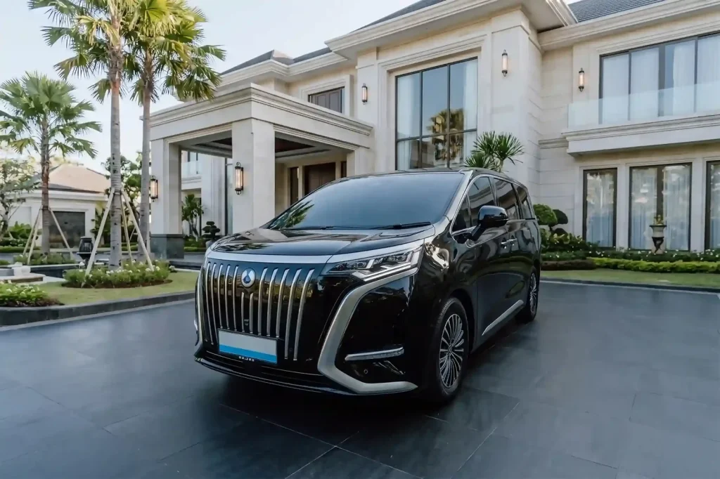 Black Denza D9 electric MPV parked at a Bali villa entrance